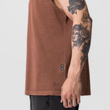 Tech Essential Relaxed Cutoff tank in faded rust, worn by model showing side view
