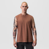Tech Essential Relaxed Cutoff sleeveless tee in faded rust, worn by model with arms at sides