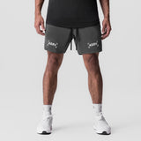Tetra-Lite 7" Linerless Short in raven, modeled from front with white sneakers and black tank top