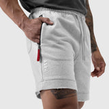 Tech Essential Sweat Short in heather grey worn by model, side view with hand in pocket