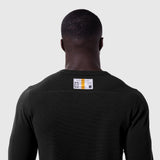 Black waffle knit longsleeve worn by model, back view with branded label visible