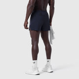Aerotex 3" Distance Short in navy, worn by model from behind, paired with white socks and sneakers