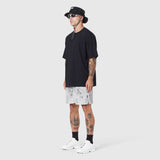 Black Supima Ice-Skin Reversible Tee worn with patterned shorts, side view on model
