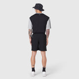 Reversible tee in black and grey worn by model from back, paired with black shorts and bucket hat