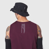 Warpflexx-Lite Training Tank in merlot, back view on model with tattoos wearing black bucket hat