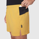 Aerotex Distance Run Short in amber yellow with black pocket detail, worn by model showing side view