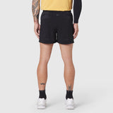 Aerotex Distance Run Short in black, rear view on model wearing yellow top and white sneakers