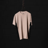 SM'23 Mesh Panel Oversized Tee in beige and black, displayed on hanger against dark brick wall