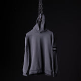 SP'20 Garment-Dyed Patch Hoodie in grey, displayed on hanging chain against black background