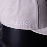 SM'23 Valley of Fire Low Pro Hat in grey, closeup detail of embroidered logo on brim