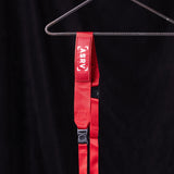 flatlay WN'19 Camera Strap in red with black hardware, hung on hanger