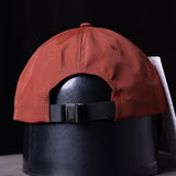 SP'23 Hybrid Sport Cap in rust red with black strap, displayed on mannequin head against dark background