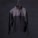 WN'23 Panel Quarter Zip Jacket in black and gray, displayed on hanger against dark brick background
