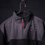 WN'23 Panel Quarter Zip Jacket in charcoal gray, displayed on hanger with close-up detail of zip and label