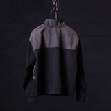 WN'23 Panel Quarter Zip Jacket in black and grey, displayed on hanger against dark background