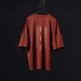 SM'23 Mesh Oversized Jersey in rust red, displayed on hanger against dark background