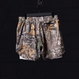 Flatlay of FA'23 5" Liner Short in camo pattern, hung on black hanger against dark background