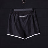 flatlay Reflective 3" Run Short in black with white trim, front view on hanger