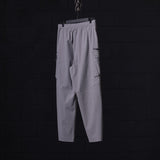 WN'23 Tetra™ City Pant in grey, hanging on display against dark background