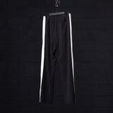 SM'24 Waffle Knit Sweat Pant in black with white side stripes, hanging on hanger