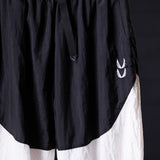 Oversized track pant in black and white, worn on model, showing side detail and branding