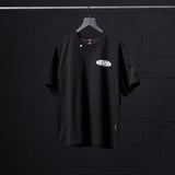 Black Tech Essential Relaxed Tee with Global Reach logo on hanger against dark background
