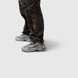 Dark camo ripstop relaxed track pant worn with white sneakers, front view
