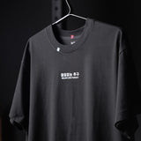 Black Tech Essential Relaxed Tee with 'Relentless Pursuit' graphic, displayed on hanger