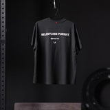 Black Tech Essential Relaxed Tee with 'Relentless Pursuit' graphic, hanging on hanger