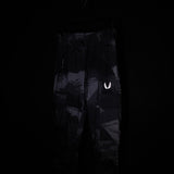SM'20 Cargo High Rib pants in black with reflective branding, front view on model