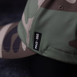 Water-resistant cinch hat in sage green and mauve, detail shot of label and seaming
