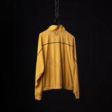 SM'24 Track Jacket in golden yellow, displayed on hanger showing back with wing emblem