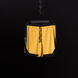 SM'24 4" Hybrid Liner Short in yellow and black, hanging on chain against dark background