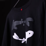 Black graphic capsule long-sleeve tee with white and gray fish design, worn on model