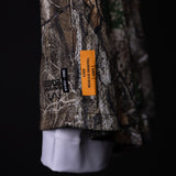 FA'23 Training Division Mesh Shorts in camo worn with white socks, detail shot of label