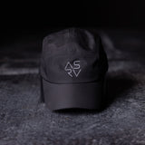 flatlay ASRV Vented Hat in black, angled front view on dark textured surface