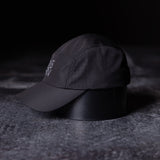 flatlay WN'22 Vented Hat in black, side angle view on textured surface