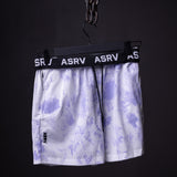 SM'22 Tie Dye Painted Shorts in purple and white, hanging on display
