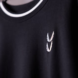Black crew neck sweatshirt with white winged logo detail, worn on model
