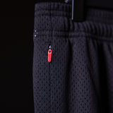 Training Division Mesh Shorts in black, worn with red zip detail visible on thigh