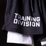 FA'23 Training Division mesh shorts in black worn by model, showing white underlay and embroidered logo detail