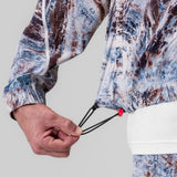 Aerotex Track Jacket in blue/brown camo, model wearing jacket with hand detail showing drawcord
