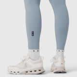 Model wearing light sky LYCRA® ADAPTIV leggings with white socks and white sneakers, front and back view