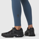W002 LYCRA® ADAPTIV Legging in storm blue, worn with black running shoes, side view