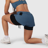 W025 Tetra-Lite Liner Short in storm blue, worn by model in kneeling pose