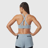 Light sky LYCRA® hybrid sports bra with cross-back straps, worn by model from behind