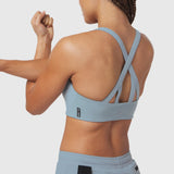 LYCRA® Hybrid Sports Bra in light sky, back view on model with arms raised