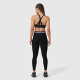 Black LYCRA® ribbed legging worn by model, back view, showing strappy sports bra