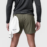 Tetra-Lite 5" Linerless Short in olive, worn by model holding white towel, back view