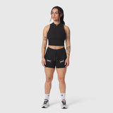 Black ribbed mockneck tank on model, paired with black shorts, front view